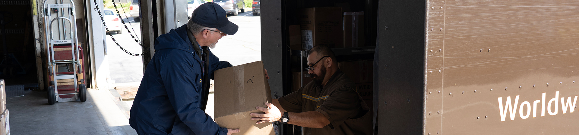 A Receiving Services worker accepts a package from a delivery person.
