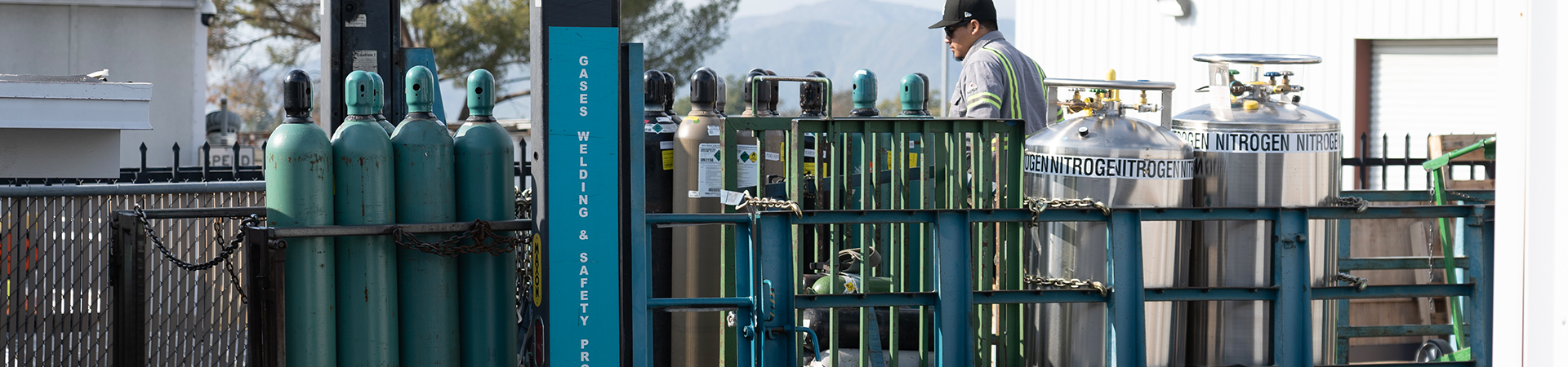 A Receiving Services worker stands among gas canisters.