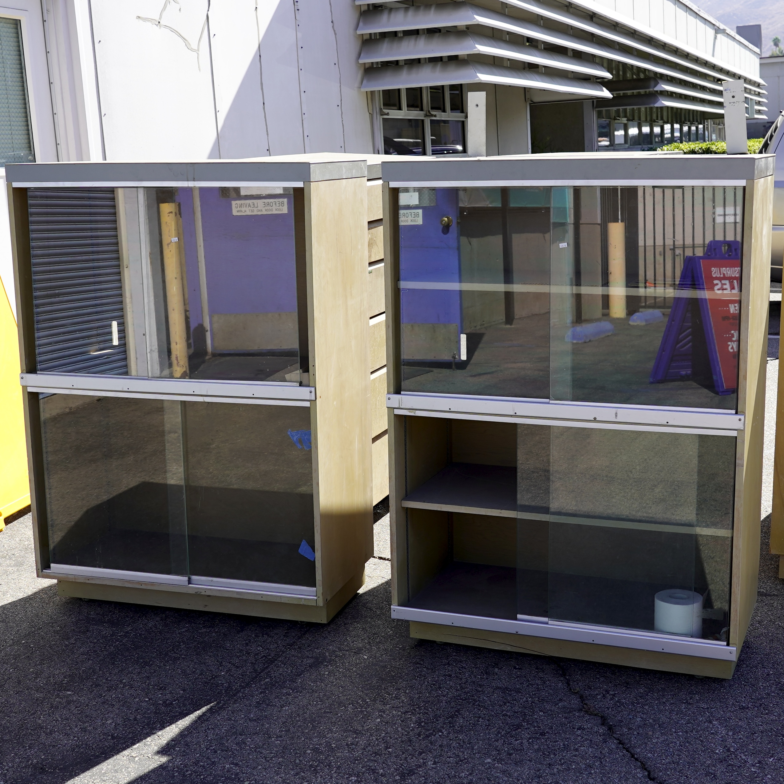 Vintage display/storage cabinets featuring light wood-grain laminate bodies and sliding glass doors.